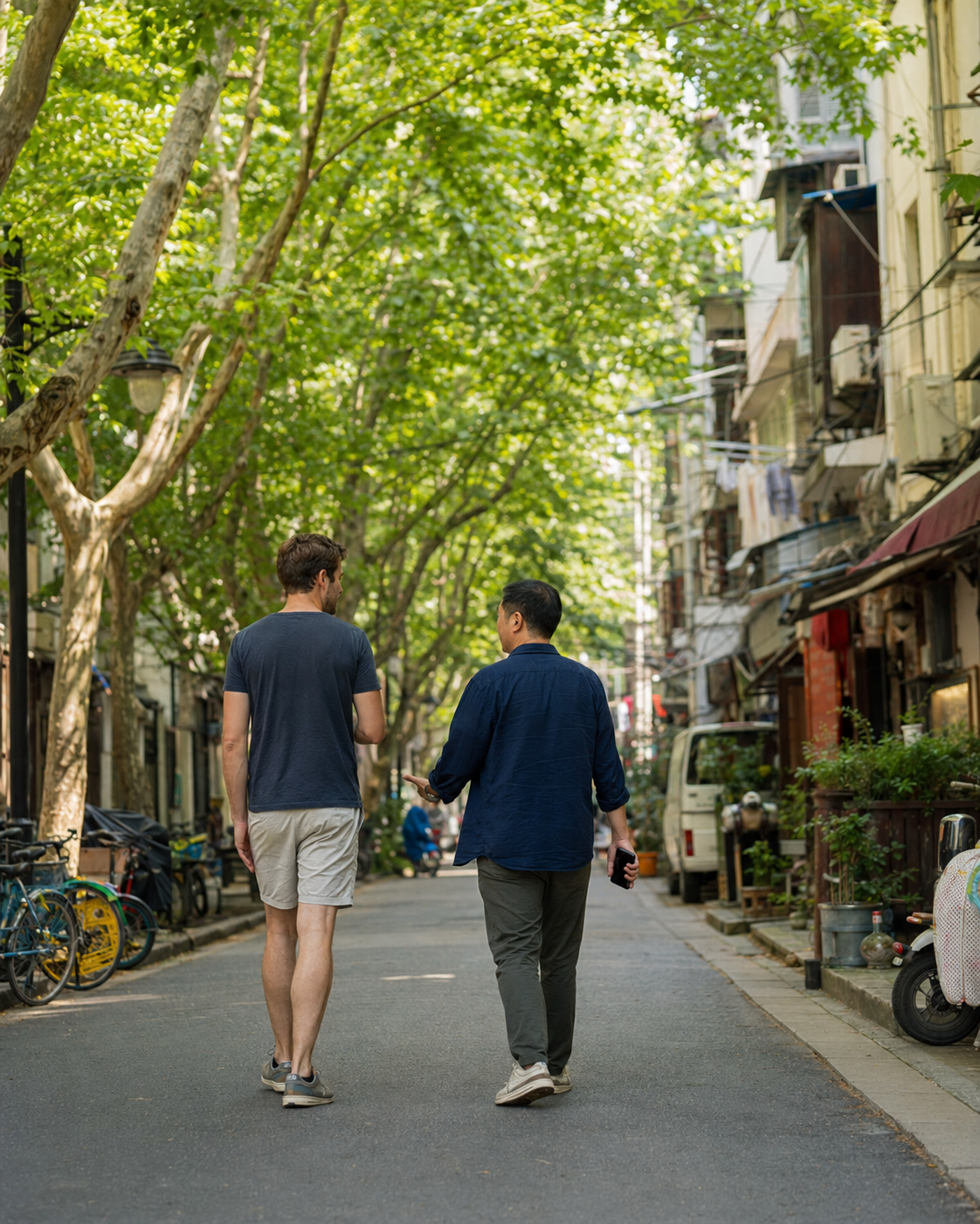 Two people walking through a leafy Shanghai neighborhood